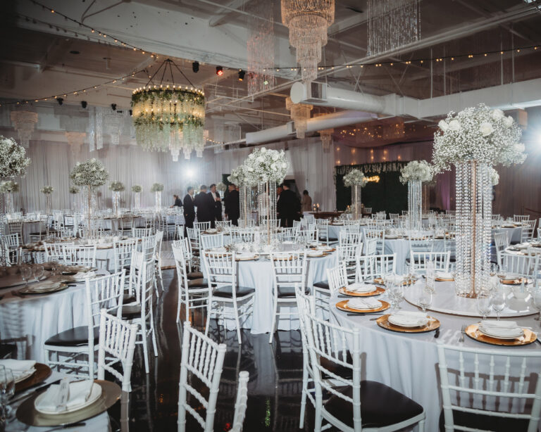 Elegant wedding reception decorated with white flowers and crystal chandeliers